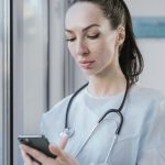 Doctor using a smartphone, representing a doctor personal brand online